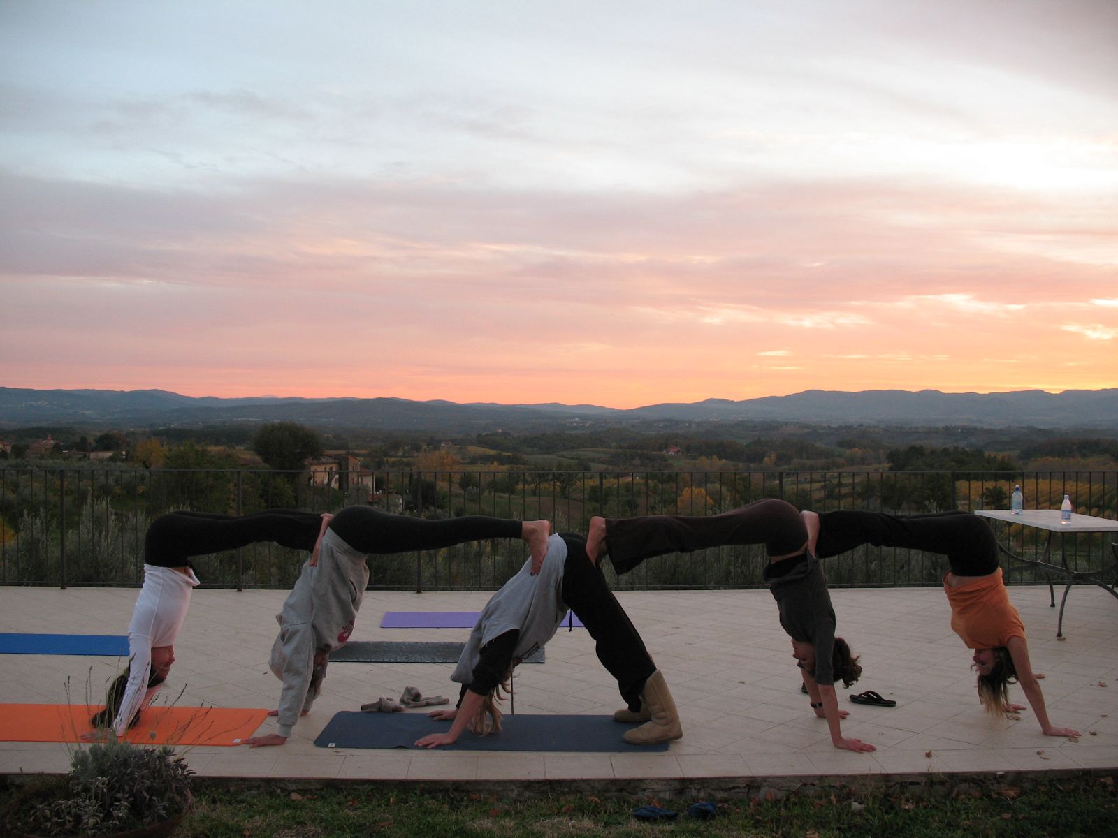 Group yoga downward dog at sunset with panoramic views