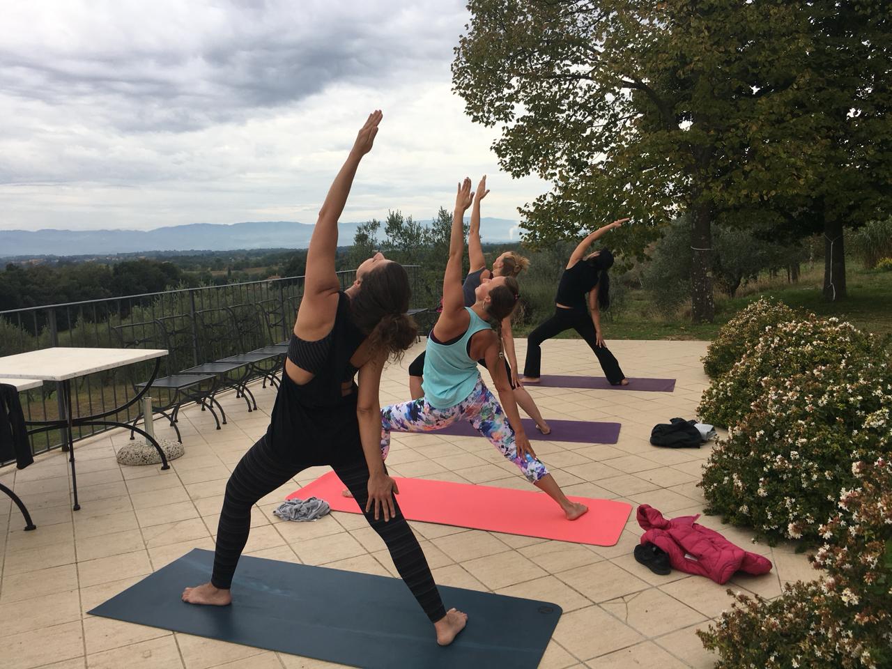 Group yoga triangle pose on the retreat terrace